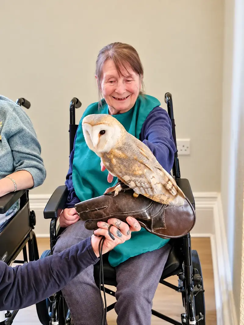 A Springfields resident smiling during a visit from a barn owl